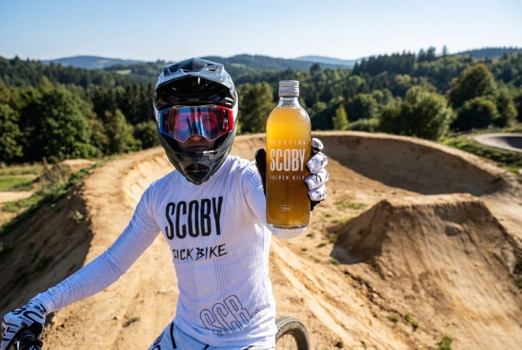biker na kole a drží kombuchu